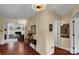 Hallway with hardwood floors, neutral walls, and view into the living room with fireplace at 8506 Graham Rd, Denver, NC 28037