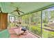 Cozy screened porch with wood flooring, ceiling fan, table, and chairs, perfect for enjoying the outdoors at 8506 Graham Rd, Denver, NC 28037