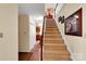 Carpeted staircase with wooden banister, enhanced by natural light and decorative wall art at 8506 Graham Rd, Denver, NC 28037