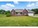 Charming red brick home boasts a well-manicured lawn and attached two car garage at 924 Secrest Hill Dr, Monroe, NC 28110
