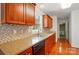 Kitchen featuring warm wood cabinets, granite countertops, and sleek black appliances at 924 Secrest Hill Dr, Monroe, NC 28110