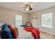 Comfortable bedroom features a ceiling fan, natural light from two windows, and neutral decor at 10044 Markus Dr, Mint Hill, NC 28227