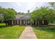 Community clubhouse with a welcoming entrance, columns, manicured landscaping, and mature trees at 10044 Markus Dr, Mint Hill, NC 28227