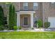 Inviting front entrance with a covered porch, lush landscaping, and a well-maintained lawn at 10044 Markus Dr, Mint Hill, NC 28227