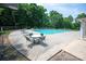 Outdoor community swimming pool with ample seating, lounge chairs, and surrounded by mature trees at 10044 Markus Dr, Mint Hill, NC 28227