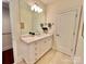 Bright bathroom with a large mirror, white vanity, neutral countertop, and tile floors at 1025 N Sharon Amity Rd, Charlotte, NC 28211