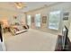 Spacious carpeted bedroom featuring a bed, lamps, and three windows at 1025 N Sharon Amity Rd, Charlotte, NC 28211
