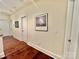 This hallway has hardwood floors, neutral walls, and decorative artwork at 1025 N Sharon Amity Rd, Charlotte, NC 28211
