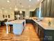 Bright kitchen with stainless steel appliances, dark cabinetry, and a central island with bar seating at 1025 N Sharon Amity Rd, Charlotte, NC 28211