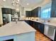 Well-lit kitchen featuring stainless steel appliances, dark cabinets, an island, and a view of the sink at 1025 N Sharon Amity Rd, Charlotte, NC 28211