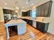 Spacious kitchen with stainless steel appliances, dark cabinets, and a large island for dining and food prep at 1025 N Sharon Amity Rd, Charlotte, NC 28211