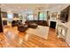 Open-concept living room featuring a fireplace, comfortable seating, and hardwood floors flowing into the kitchen at 1025 N Sharon Amity Rd, Charlotte, NC 28211