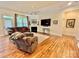 Comfortable living room with a fireplace, large windows, and hardwood flooring at 1025 N Sharon Amity Rd, Charlotte, NC 28211