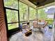 Cozy screened porch with fan, tiled floor and furniture for outdoor entertaining at 1025 N Sharon Amity Rd, Charlotte, NC 28211