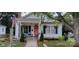 Charming cottage-style home with a welcoming porch, beautiful plants, and mature trees at 105 N Central Ave, Belmont, NC 28012