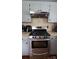 Kitchen features stainless steel range and gray cabinets with tiled backsplash at 105 N Central Ave, Belmont, NC 28012
