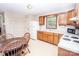 Bright kitchen with wooden cabinets, standard appliances, and a view to the backyard from the window at 110 Book Ct, Statesville, NC 28677