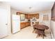 Functional kitchen with wooden cabinetry, white appliances, and a cozy dining area with natural light at 110 Book Ct, Statesville, NC 28677