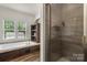 Modern bathroom features a large soaking tub, a separate glass shower, and a storage shelf at 113 Robinette Ln, Statesville, NC 28625