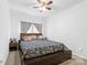 Cozy bedroom with a patterned bedspread, ceiling fan, and natural lighting at 116 Maggie Dr, Mount Holly, NC 28120
