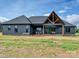 A backyard view reveals a home with dark siding and a striking gable design over an outdoor living space at 1172 Springlake Rd, York, SC 29745