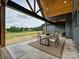 A covered patio features both a dining table and comfortable lounge chairs, with views of a lush green field at 1172 Springlake Rd, York, SC 29745