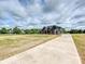 A long concrete driveway leads to a dark-sided home with stone accents and timber detailing, set in a spacious yard at 1172 Springlake Rd, York, SC 29745