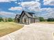 A long concrete driveway leads to a beautifully appointed home with mixed exteriors and a spacious three car garage at 1172 Springlake Rd, York, SC 29745