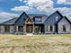 A stunning exterior featuring dark siding, stone accents, wood details, and lush landscaping is pictured on a sunny day at 1172 Springlake Rd, York, SC 29745