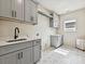 This modern laundry room features gray cabinetry, a black faucet, and stylish patterned tile flooring at 1172 Springlake Rd, York, SC 29745