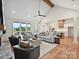 Bright living room with vaulted ceilings, modern ceiling fan, fireplace, and view to the backyard and open kitchen at 1172 Springlake Rd, York, SC 29745