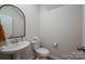 Powder room features pedestal sink, arched mirror, and modern fixtures at 13025 Cinnamon Fern Ln, Charlotte, NC 28227