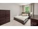 Cozy bedroom featuring a bed with throw blanket, dark wood furniture, and natural light at 13025 Cinnamon Fern Ln, Charlotte, NC 28227