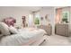 Bright bedroom featuring a bed, two dressers, and light pink decor at 13025 Cinnamon Fern Ln, Charlotte, NC 28227