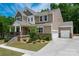 Charming two-story home with landscaped yard, stone accents, and a welcoming covered front porch at 13025 Cinnamon Fern Ln, Charlotte, NC 28227