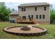 Inviting backyard fire pit area with a stone surround, gravel, and lush green lawn at 13025 Cinnamon Fern Ln, Charlotte, NC 28227