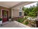 Inviting covered porch featuring a red front door adorned with a wreath and decorative planters at 13025 Cinnamon Fern Ln, Charlotte, NC 28227
