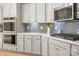 New kitchen with stainless appliances, gray backsplash, white countertops, and gray cabinets at 13025 Cinnamon Fern Ln, Charlotte, NC 28227