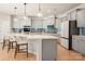 Gourmet kitchen boasts gray cabinets, quartz countertops, stainless appliances, and large island at 13025 Cinnamon Fern Ln, Charlotte, NC 28227