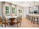 Sunlit kitchen and breakfast nook feature large windows, modern light fixture, and hardwood floors at 13025 Cinnamon Fern Ln, Charlotte, NC 28227