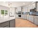 Modern kitchen with island seating, stainless appliances, gray cabinets, and tile backsplash at 13025 Cinnamon Fern Ln, Charlotte, NC 28227