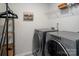 Functional laundry room with front-load washer and dryer, overhead shelving, and stylish decor at 13025 Cinnamon Fern Ln, Charlotte, NC 28227