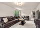 Large living room with a comfortable leather couch, bright windows, and an open layout at 13025 Cinnamon Fern Ln, Charlotte, NC 28227