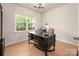 Bright office space with natural light, modern desk, and hardwood floors for a productive work environment at 13025 Cinnamon Fern Ln, Charlotte, NC 28227