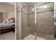 Modern shower with gray tiling and a glass door, adjoining the main bedroom at 13025 Cinnamon Fern Ln, Charlotte, NC 28227