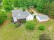 Aerial view of home with lush green lawn, mature trees, detached garage and long driveway at 132 Homeplace Ln, Statesville, NC 28625