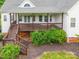View of the wood deck with brown railings, steps, and manicured landscaping at 132 Homeplace Ln, Statesville, NC 28625