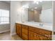 Bright bathroom featuring a double vanity with oak cabinets, and a large mirror at 132 Homeplace Ln, Statesville, NC 28625