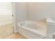A relaxing white bathtub is set in a tiled bathroom, near walk-in closet at 132 Homeplace Ln, Statesville, NC 28625
