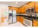 Open kitchen with stainless steel appliances, oak cabinets, and tile backsplash at 132 Homeplace Ln, Statesville, NC 28625